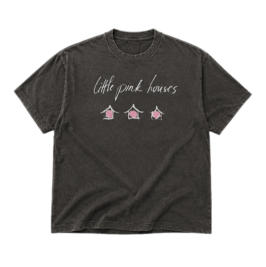 A dark gray acid-wash t-shirt with 'Little pink houses' written in white script across the chest, above three small pink house illustrations.